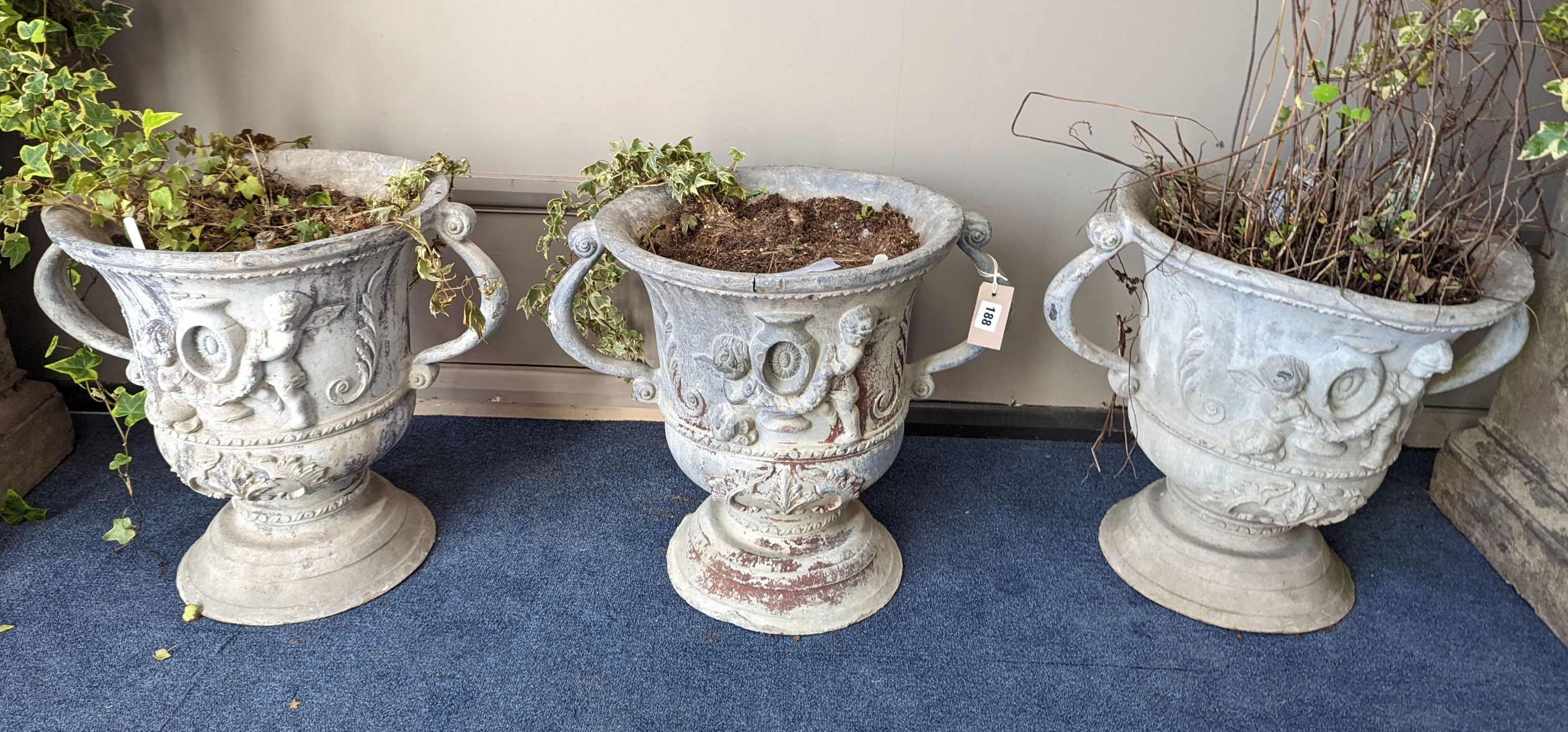 A set of three Victorian lead two handled garden planters, moulded with cherubs, diameter 38cm, height 43cm